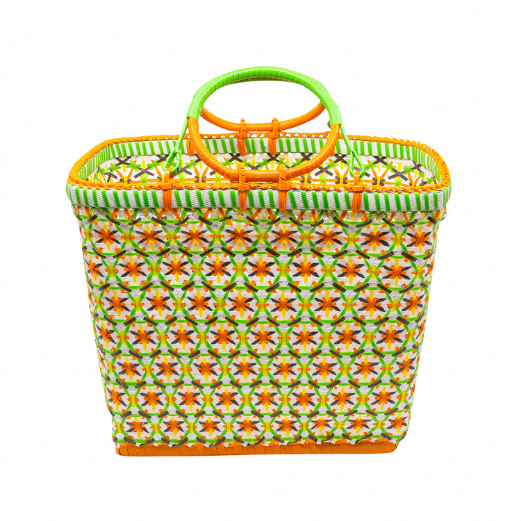 A Belongil basket featuring a star pattern, with green and orange stripes, and a rattan handle and base.
